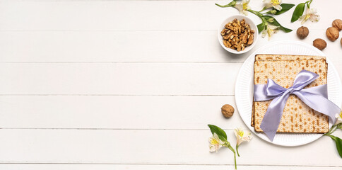 Jewish flatbread matza for Passover, flowers and walnuts on light wooden background with space for text