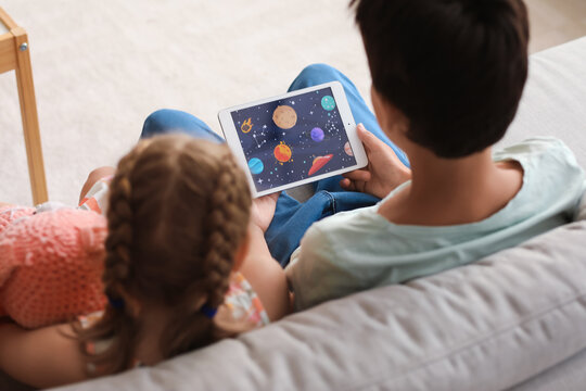Little boy and girl watching cartoons on tablet computer at home, closeup - Powered by Adobe