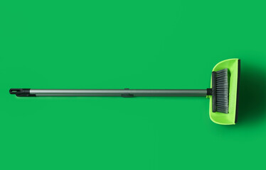 Dustpan with cleaning broom on green background