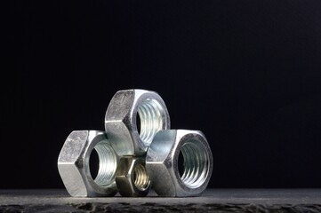 composition of nuts bolts and scraps of metal laid out on a dark background.