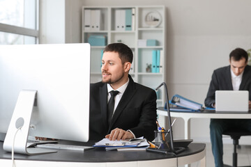 Male accountant working with computer at table in office