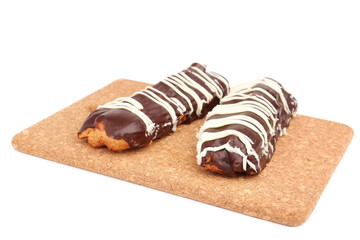 Board with sweet chocolate eclairs isolated on white background