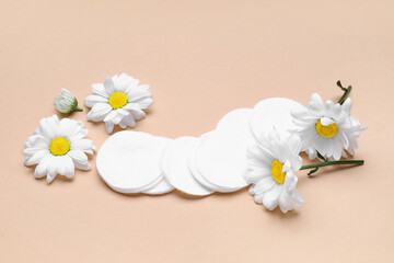 Composition with cotton pads and chamomile flowers on color background