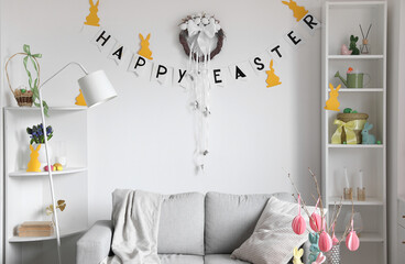 Interior of living room decorated for Easter celebration with wreath and sofa