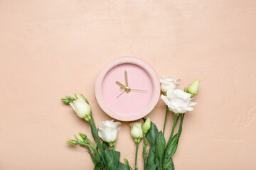 Alarm clock and beautiful eustoma flowers on color background
