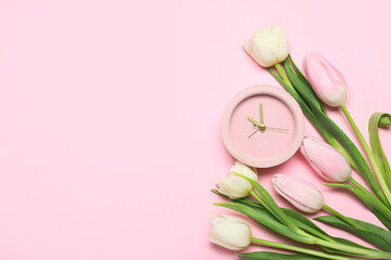 Composition with alarm clock and beautiful tulip flowers on pink background