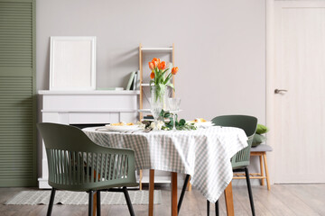 Dining table with setting for International Women's Day celebration and flowers in living room