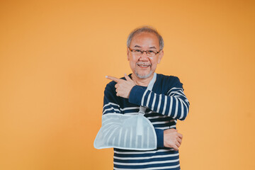 Arm broken. Senior male sling support hand confident smile broken after accident wear arm splint...