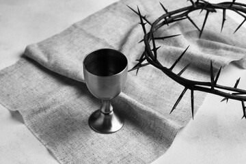 Fototapeta na wymiar Wine cup with crown of thorns and cloth on white background, closeup