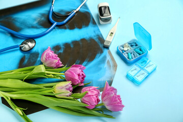 Obraz na płótnie Canvas Medical supplies with tulips on blue background. Hello spring