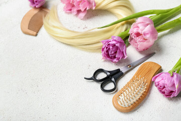 Obraz na płótnie Canvas Hairdresser's tools with tulips on white background, closeup. Hello spring