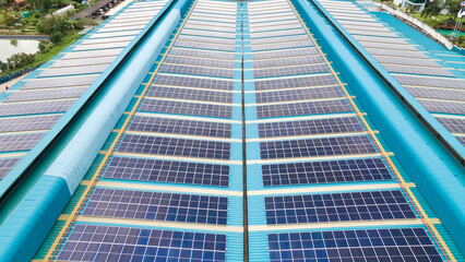 Aerial view of blue photovoltaic solar panels rooftop. Construction Solar panels or Solar cells on industrial factory rooftop. Production of sustainable energy or green ecological electricity concept.