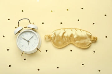 Composition with sleeping mask, alarm clock and confetti on color background. World Sleep Day...