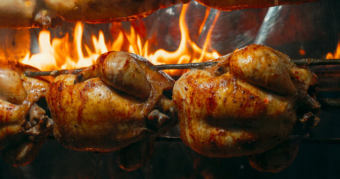 Delicious Golden Brown Rotisserie Chickens Turn On Spit. Tasty Grilled Chicken. Food Concept. Street Food. Appetite Food. Juicy Chicken Grilled On Rolling Spit In Store. street food