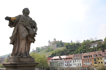 Fototapeta na wymiar Marienberg Fortress viewed over a historic statue in Würzburg, Germany