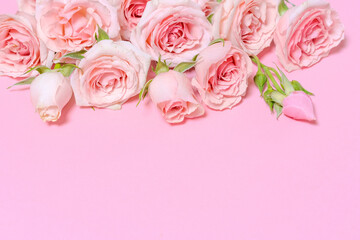 Delicate blooming pink flowers, blooming roses festive pink background, pastel bouquet with floral card, selective focus
