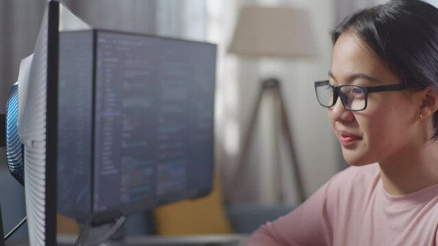 Close Up Of Asian Teen Girl Programmer Creating Innovative Software Engineer Developing App, Program, Video Game On Desktop Computer At Home. Terminal With Coding Language 
