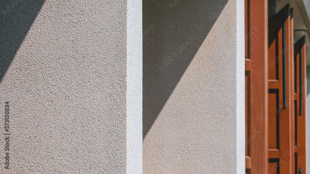 Wall mural Sunlight and shadow on surface of white vertical cobblestone Shading Fins with wooden windows outside of Vintage House in perspective side view