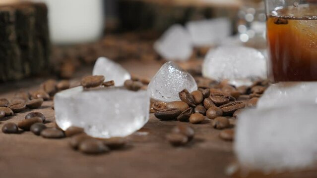 Coffee house concept. Ice cubes and coffee beans on wooden board. Food art. Delicious croissants on glass bowl on the background. hd