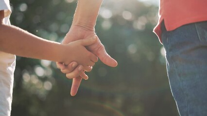 happy family father and daughter hold hands close up. Dad and baby girl hands together at sunset. Father Day. Dad and daughter are holding hands. A father extended a helping hand to his daughter child - Powered by Adobe
