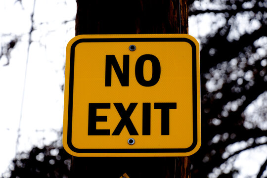 No exit yellow sign on a wooden pole - close-up