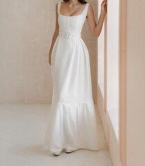 Front view of beautiful bride in the white long wedding dress. Classic sleeveless wedding dress...