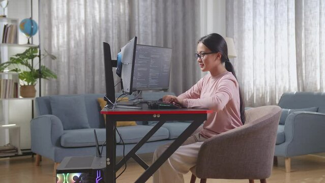 Asian Teen Girl Programmer Creating Innovative Software Engineer Developing App, Program, Video Game On Desktop Computer At Home. Terminal With Coding Language 
