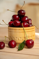 Ripe sweet cherries in wooden bowl on table close up