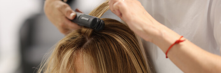 Fototapeta premium Pulling strands of hair with professional iron care