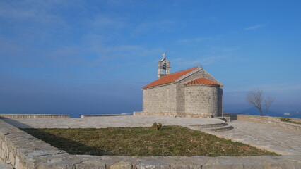 Fototapeta premium Church against the blue sky. Church in the mountains. Church of Sveti Stefan in Montenegro