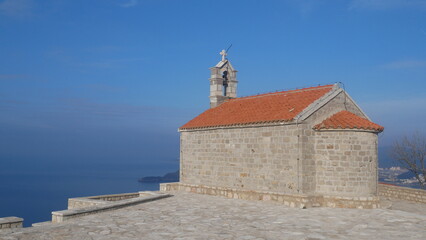 Fototapeta na wymiar Church against the blue sky. Church in the mountains. Church of Sveti Stefan in Montenegro