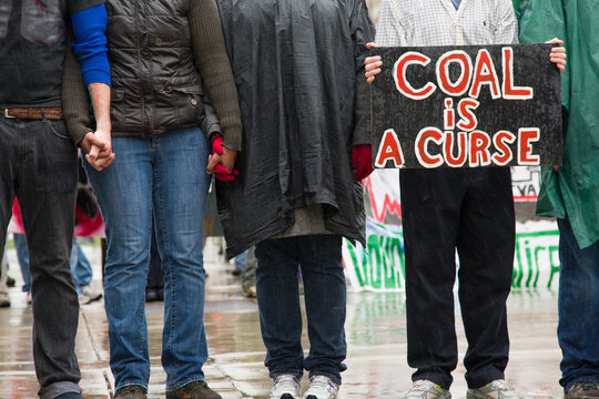 A protestor holds up signs saying 'Coal is a Curse'. The protestors were protesting against the coal industry in front of the Tennessee Valley Authority offices in Knoxville, USA.