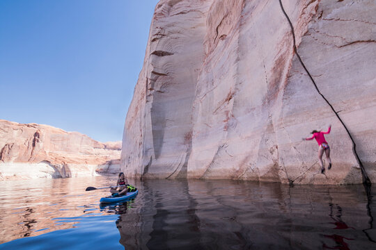 Woman jumping into water, Lake Powell, Utah, USA