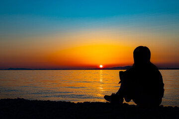 Naklejka na ściany i meble Silhouette of a woman twilight at sunset