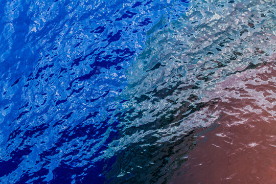 A view of the bulbous bow of a container ship underneath the surface of the ocean.
