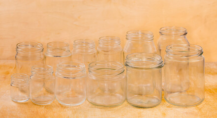 Empty glass jars different sizes on a wooden surface