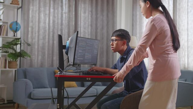 Asian Teen Girl Teaching Her Brother Creating Software Engineer Developing App, Program, Video Game On Desktop Computer At Home. Terminal With Coding Language
