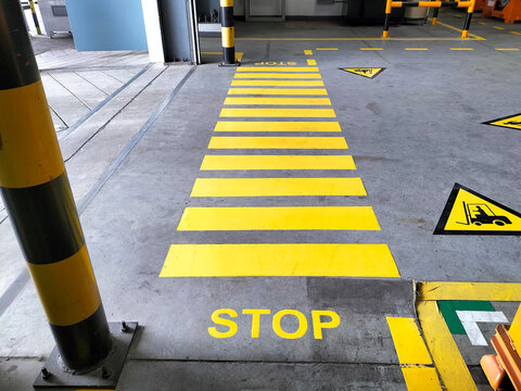 Industrial building corridor painted yellow between parallel yellow lines on abstract cement background. Sidewalk Negotiation Safety Concept	