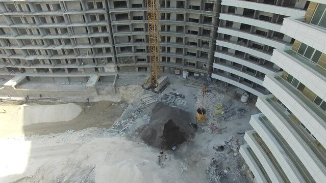 Aerial view of working excavator.
Aerial Flight Over a New Constructions Development Site with High Tower Cranes Building Real Estate. 