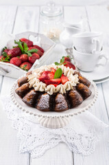 Traditional German strawberry cheese cake with fresh fruits and white chocolate cream served as close-up on a cake plate