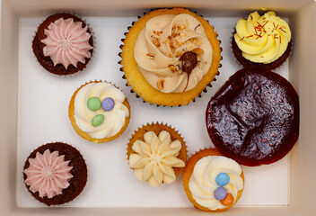 Box with tasty and colorful cupcakes in box closeup