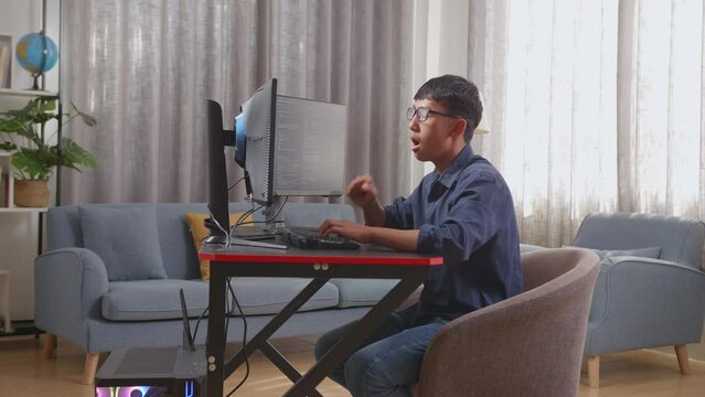 Asian Boy Programmer Yawning And Sleeping While Creating Innovative Software Engineer Developing App, Program, Video Game On Desktop Computer At Home. Terminal With Coding Language 
