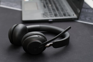 Obraz na płótnie Canvas Black wireless headset on black desk closeup