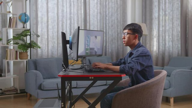 Asian Boy Programmer Learning Online From Teacher On Desktop Computer While Creating Software Engineer Developing App, Program, Video Game At Home. Terminal With Coding Language 
