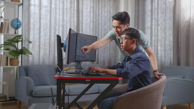 Asian Boy Students Studying Software Code From Male Teacher Or Father
