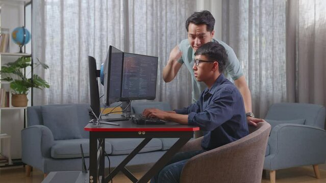Asian Father Shouting At His Son While Creating Software Engineer Developing App, Program, Video Game On Desktop Computer At Home. Terminal With Coding Language
