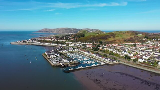 Aerial footage of the town of Deganwy in Conwy County Borough in Wales It lies in the Creuddyn Peninsula alongside Llandudno Rhos-on-Sea showing the Deganwy Marina and railway along the Conwy river