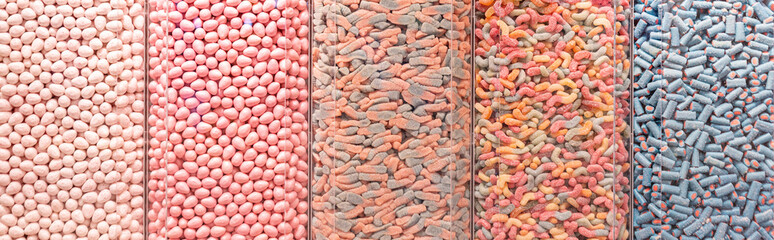 Assorted multi-colored candies in a shop window. Food texture.
