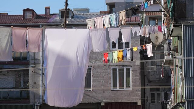 Clothes hanging to dry on clothesline outdoors inside yard of houses. Drying washed laundry in Georgia.