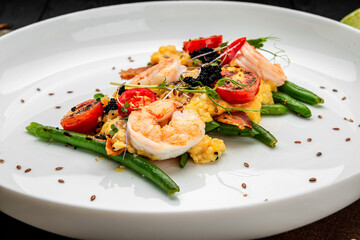 Omelet with shrimp, caviar and grilled tomatoes on a bed of green beans and bacon